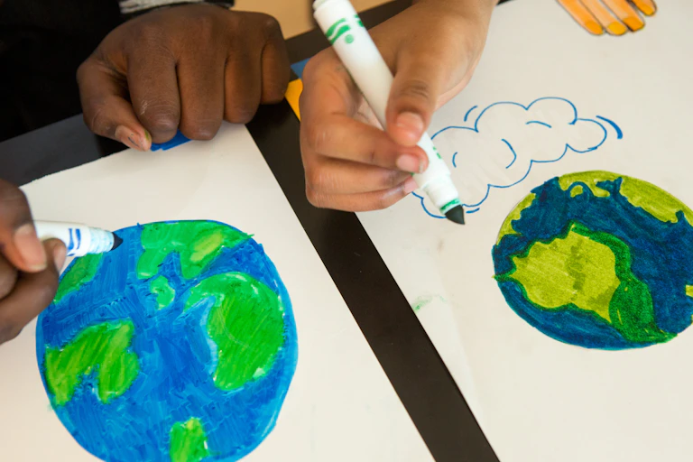 Hands seen colouring Earths.