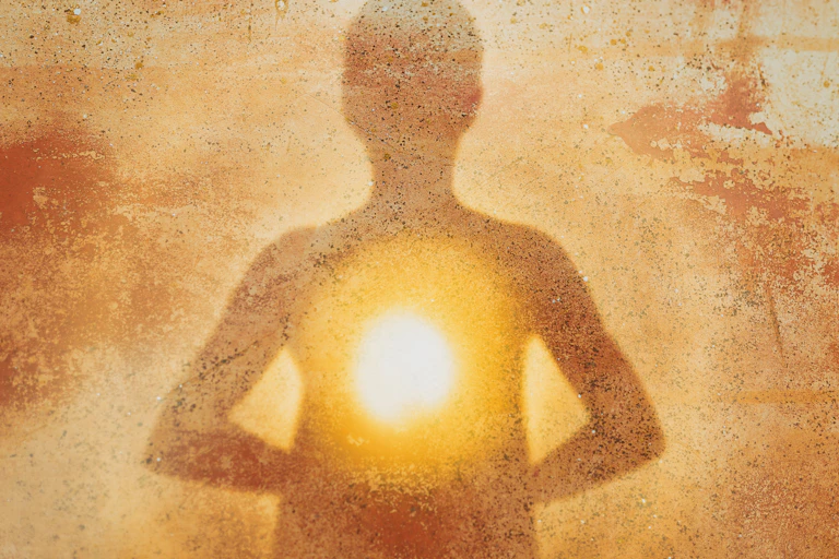 A dust-coloured silhouette of a person with a glowing heart