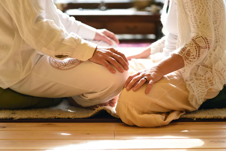 two people face each other in meditation