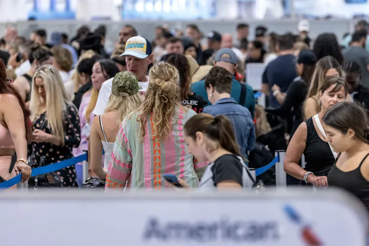 huge crowd of travellers waiting in an airport