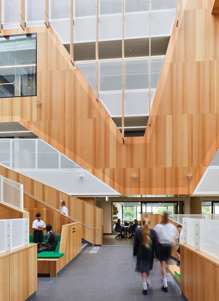A timber school interior with students walking away