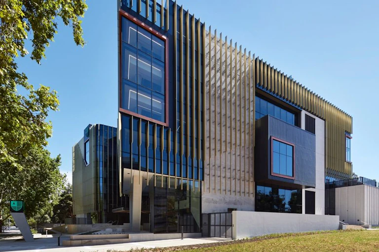 A tall glass building covered in vertical panelling