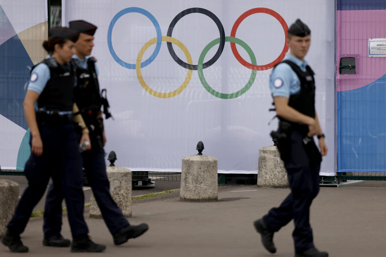 Des gendarmes français patrouillent le long des clôtures bordant le site olympique des Invalides à Paris, le 16 juillet 2024.