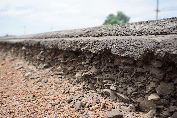 The underside of a road with aggregate material exposed.