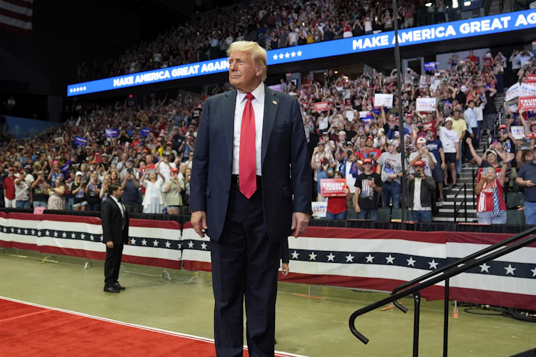 Donald Trump stands alone at a political event.