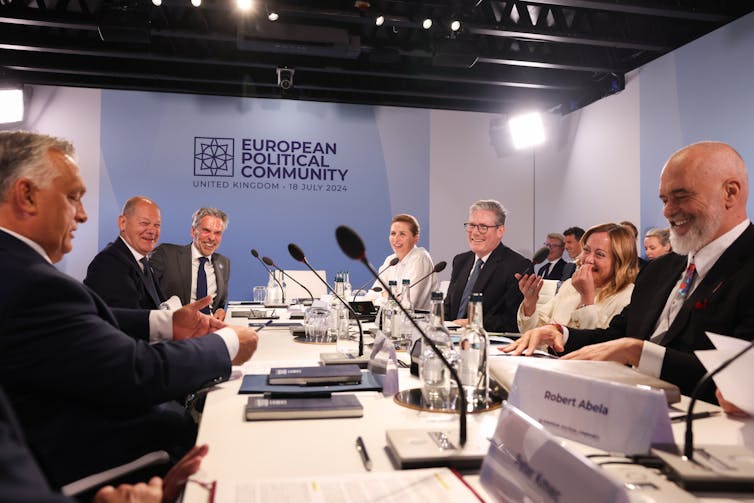 Starmer and other European leaders, including Meloni, Scholz and Abela, sit around a table and laugh.