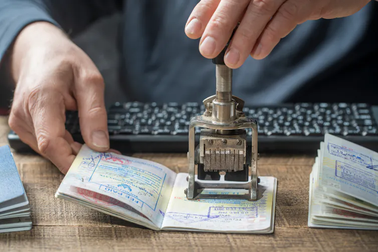 View of an official putting a stamp in a passport