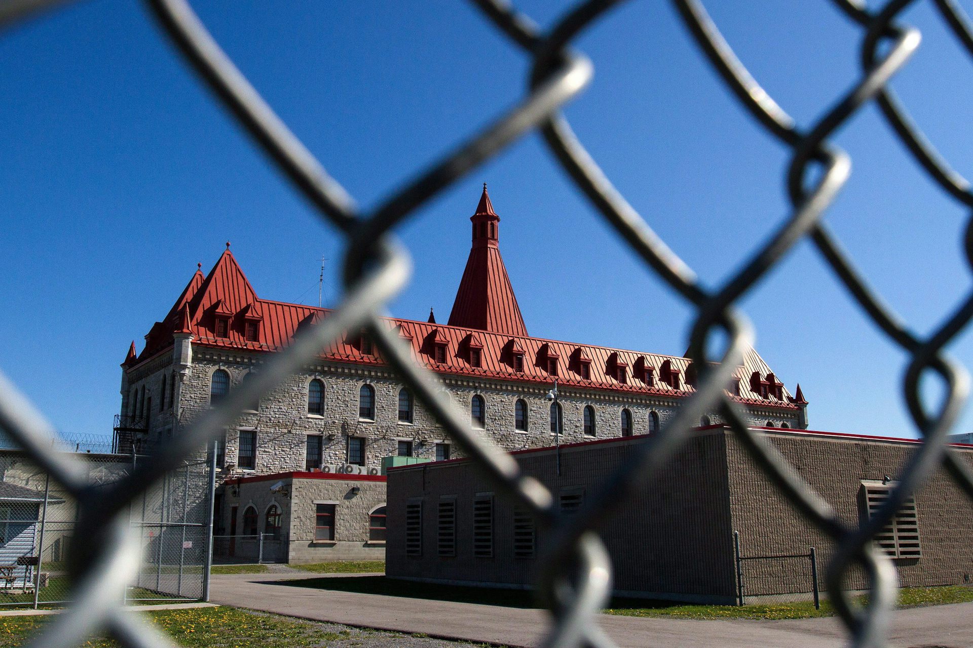 A prison behind a chain-link fence.