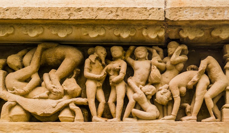 A display carved in stone into an Indian temple shows figures engaged in sex acts.