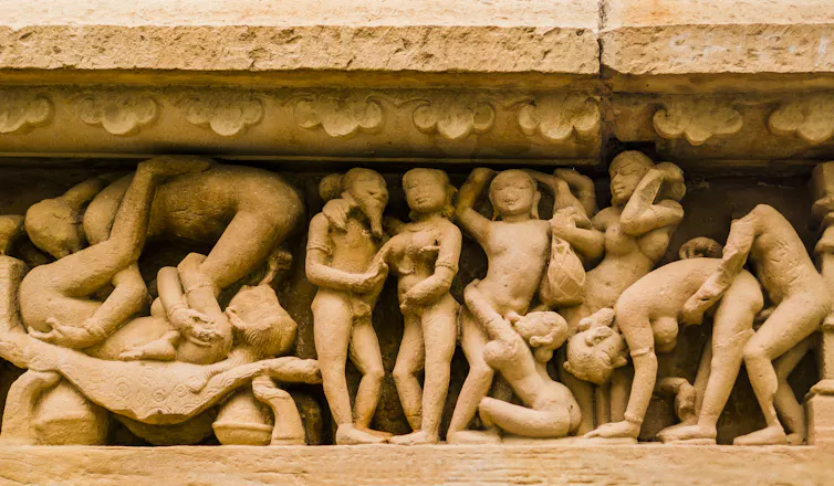 A display carved in stone into an Indian temple shows figures engaged in sex acts.