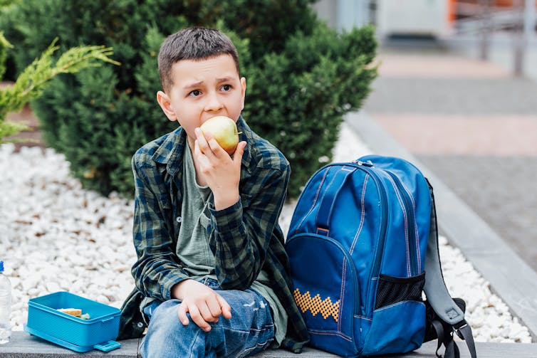 Boy eating apple outside