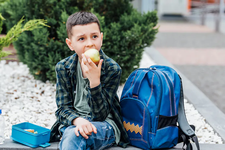 Boy eating apple outside