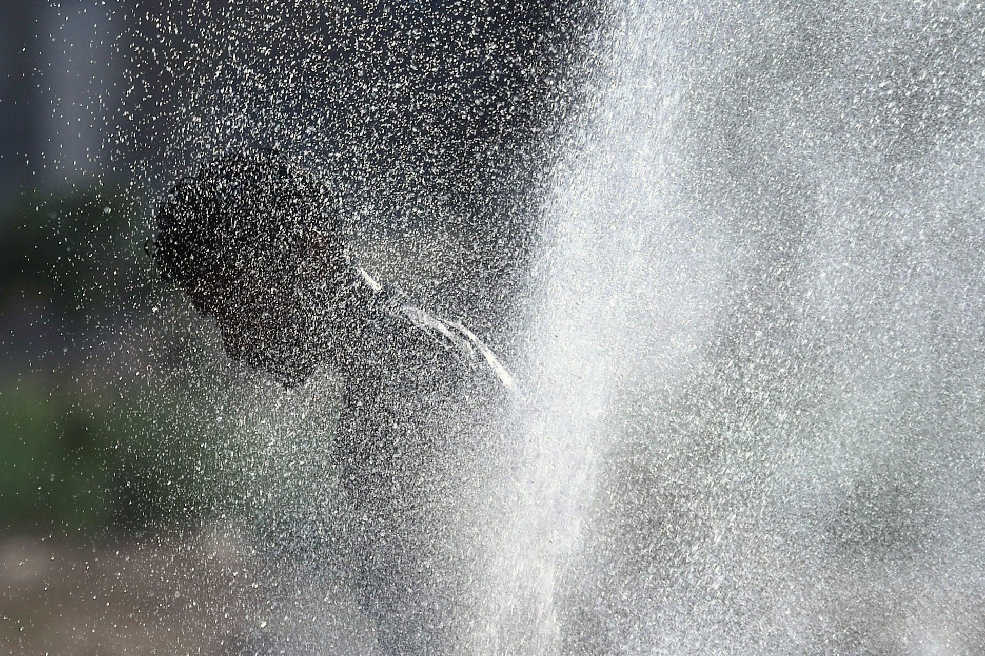 A figure obscured by a jet of water.