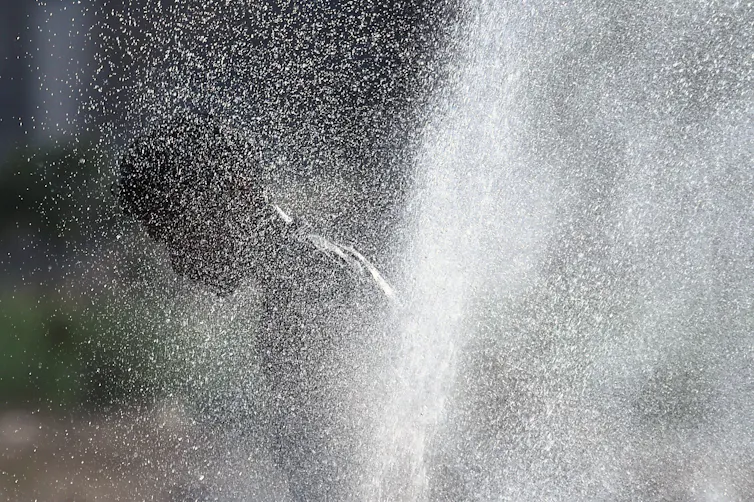 A figure obscured by a jet of water.