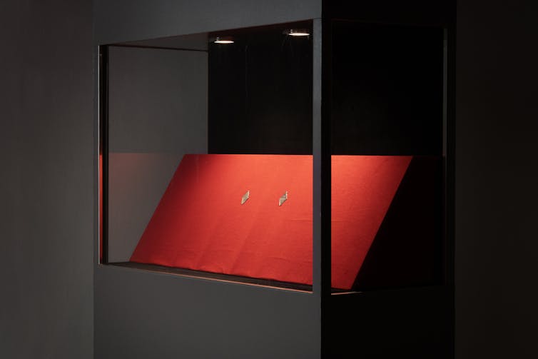 Two fake coins presented in a museum display