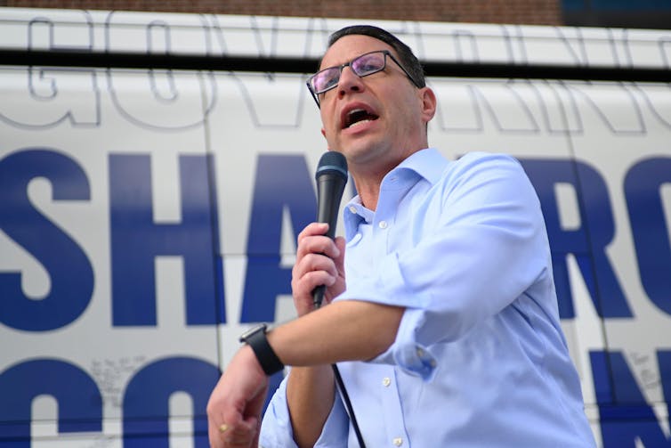 Josh Shapiro discursa em frente ao seu ônibus de batalha.