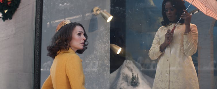 Maddie at a shop window where Cleo is modelling a dress.