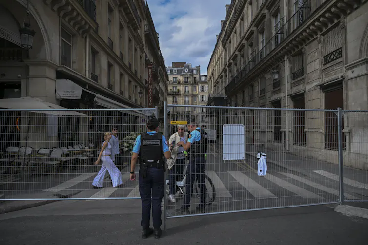 Des gendarmes vérifient les documents d’un homme à un check-point près du Musée du Louvre avant les Jeux Olympiques de Paris 2024, à Paris, le 22 juillet 2024