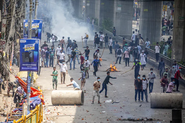 A crowd of protestors clash with police in the street in Bangladesh.