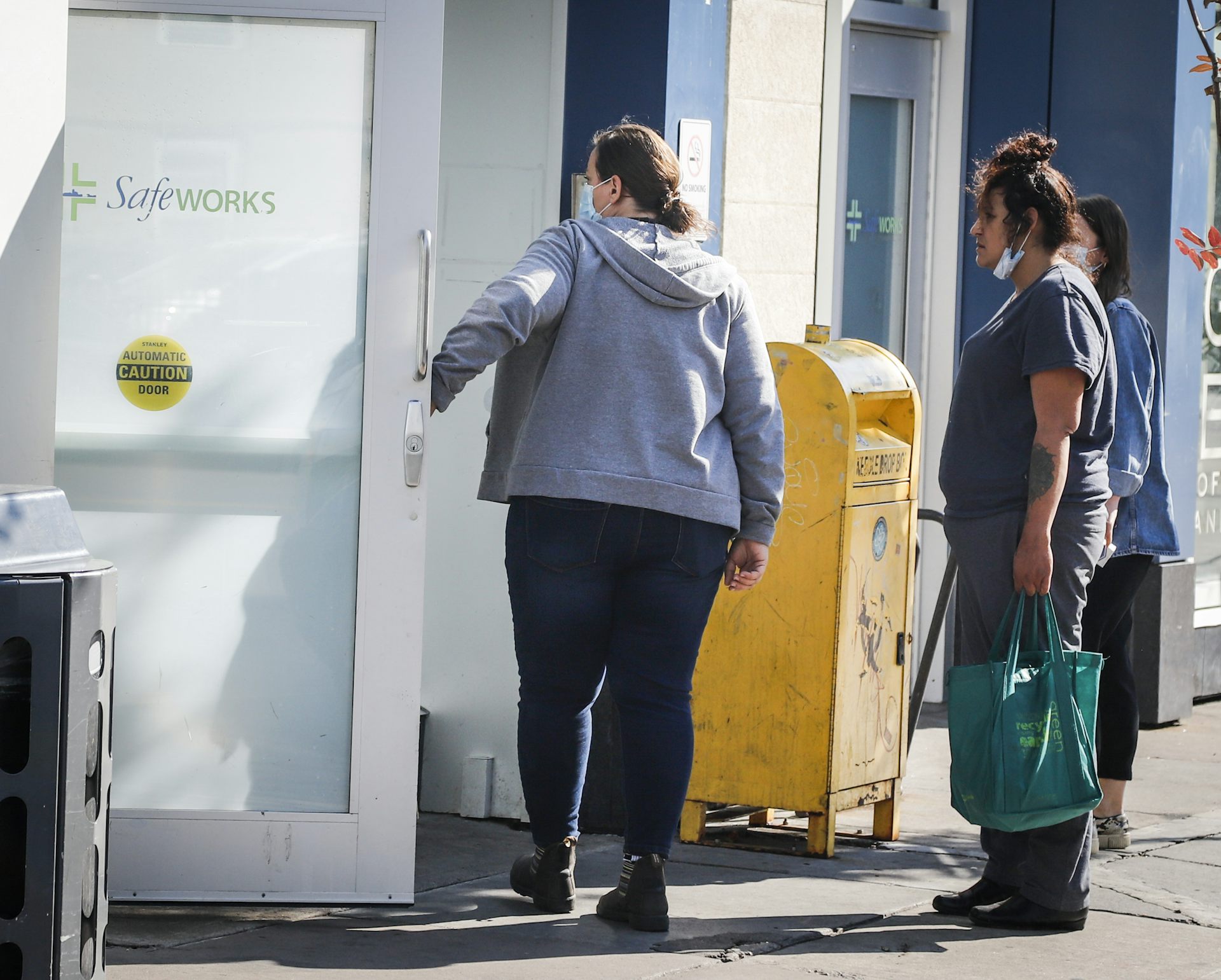 Two women stand outside a building.