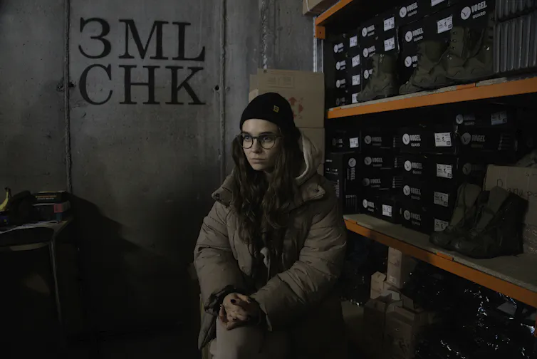 Une femme debout devant une réserve de bottes
