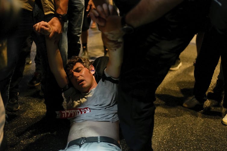 an apparently unconscious young man is being dragged