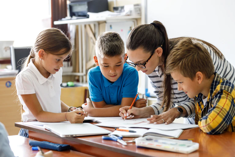 Teacher working with children at desk