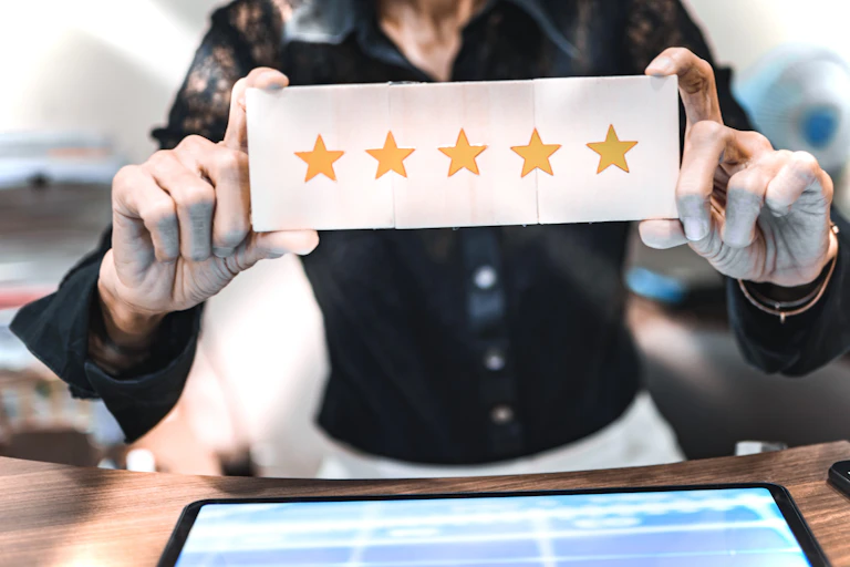 Woman holds up a five-gold-star review.