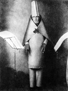 A man dressed in a strange metallic looking Dada costume.