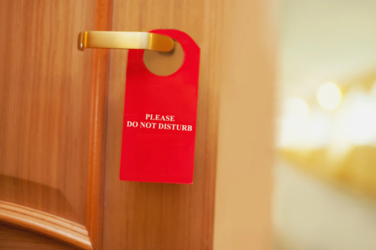 une porte de chambre d'hôtel avec la pancarte 'Please do not disturb"