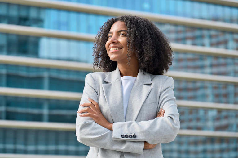 A young Black woman smiling and looking upwards.