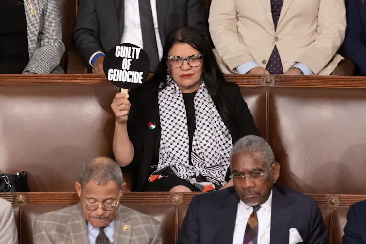 Democrat representative Rashida Tlaib holds up a sign saying 'Guilty of Genocide' as she listens to Benjamin Netanyahu speak in Congress, July 24 2024.