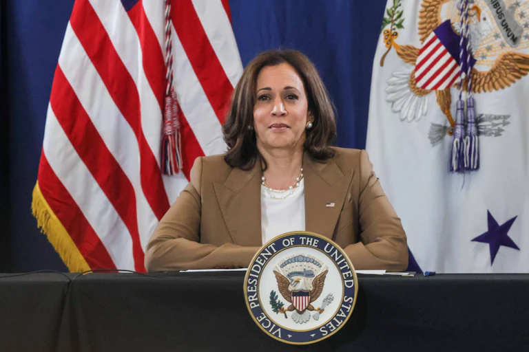 Kamala Harris standing in front of a US flag.