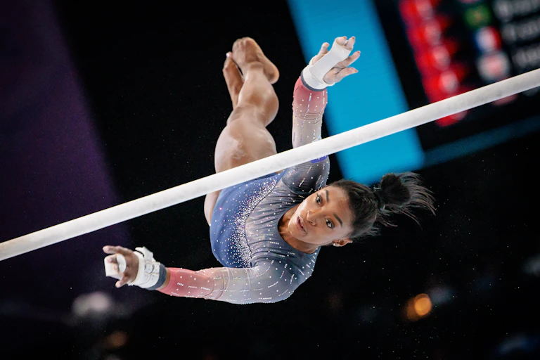 Simone Biles vuela sobre las barras asimétricas en los Mundiales de Gimnasia de Amberes en 2023.