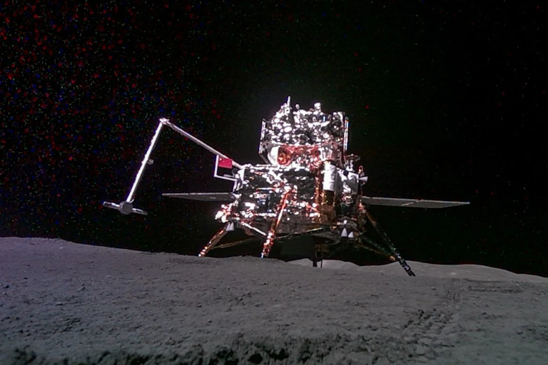 A metal lander with a bent arm coming off its side.