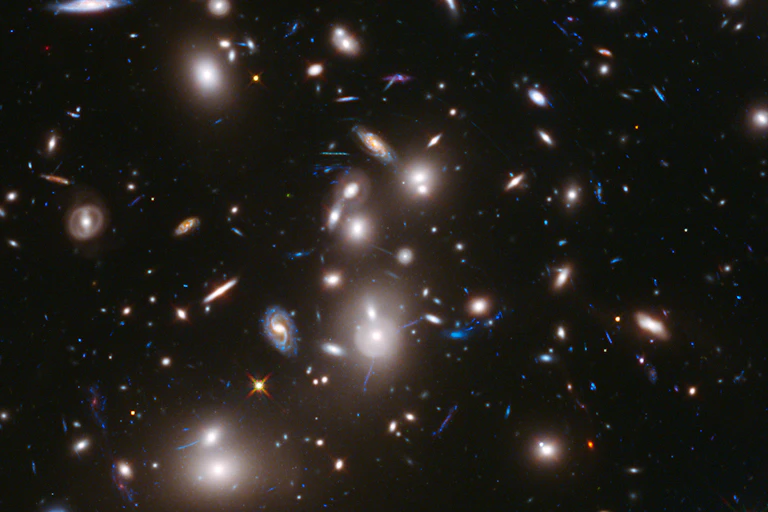 Imagem de telescópio de um aglomerado de galáxias com mais galáxias ao fundo