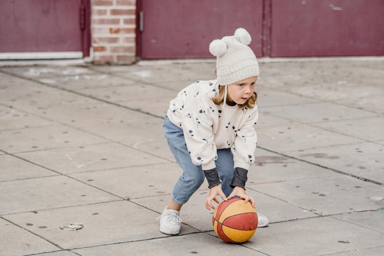 A young child plays with a basketball