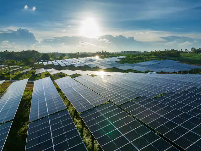 Solar panels in China with a bright sun in the background