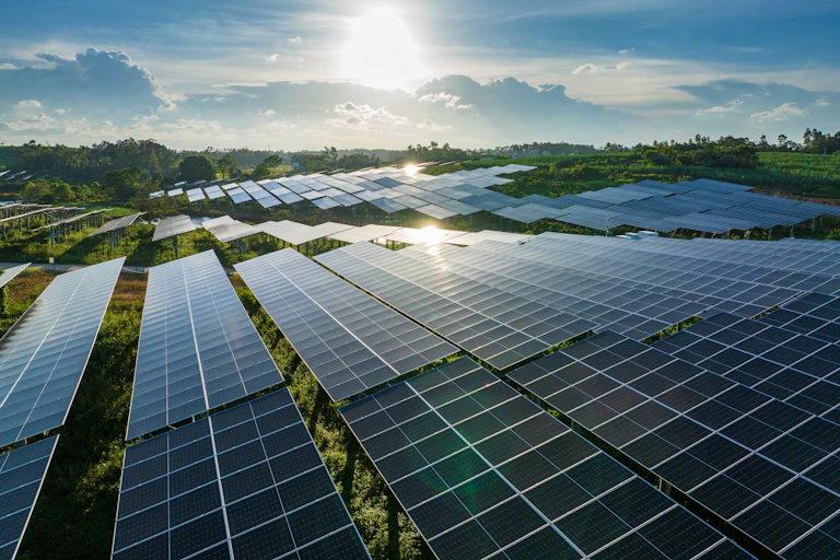 Solar panels in China with a bright sun in the background