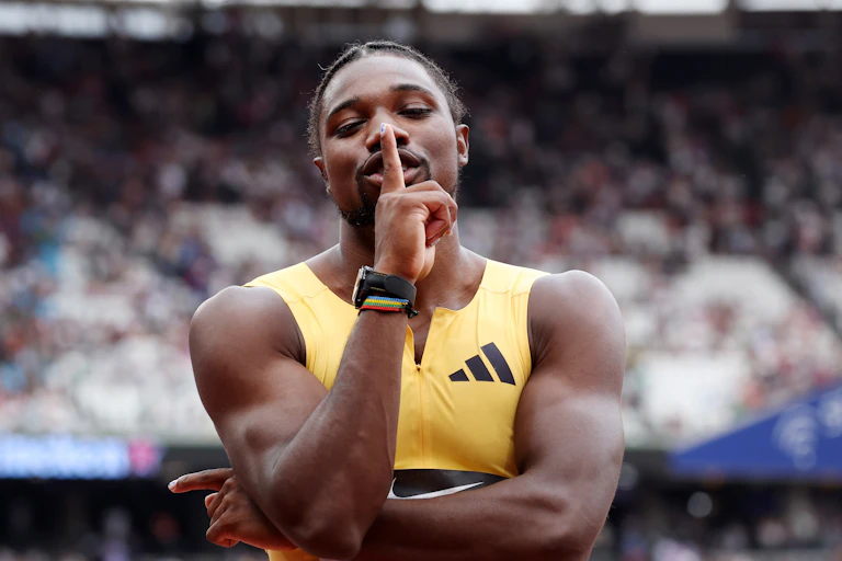 Sprinter Noah Lyles holds a finger to his lips.