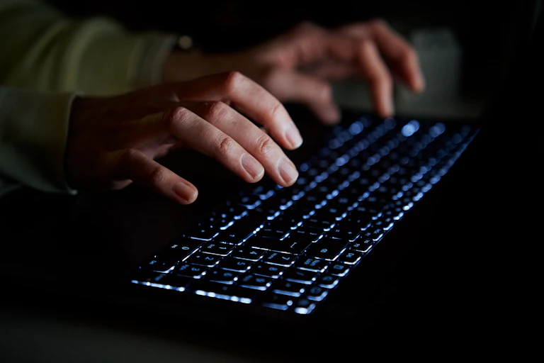 A pair of hands typing on a keyboard