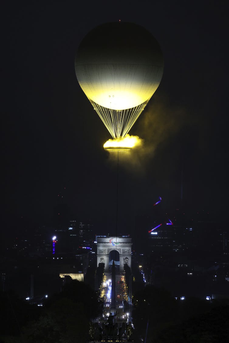 An illuminated hot air balloon above the Arc de Triomphe.