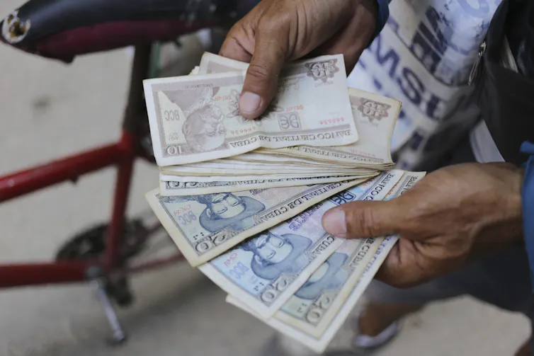 Close up of a fan of Cuban pesos seen in someone's hands