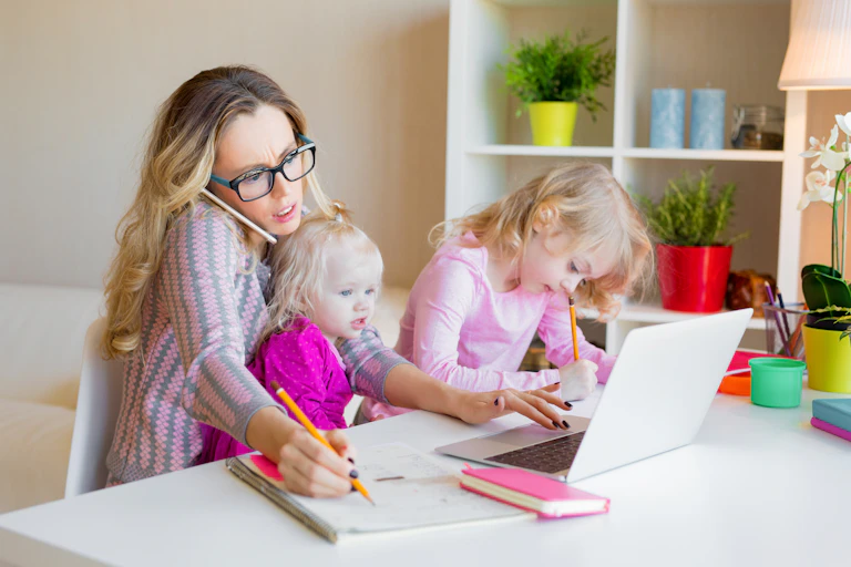 Woman juggling phone call and two young children
