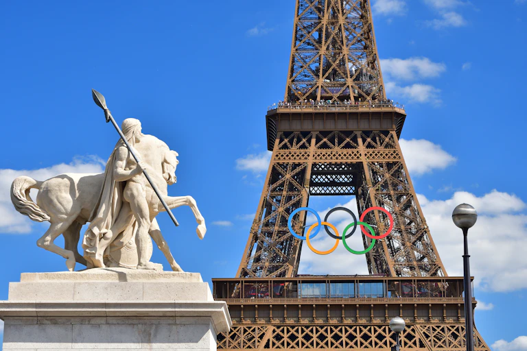 Statue, Eiffel Tower and Olympic rings.
