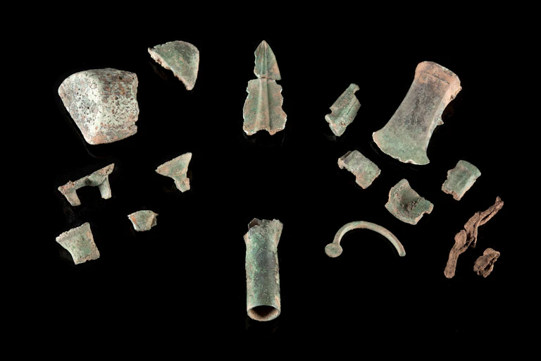 A photo of fragmented metal items arrayed on a black background.