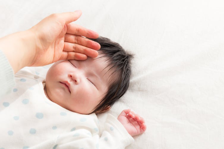 Parent strokes baby's head