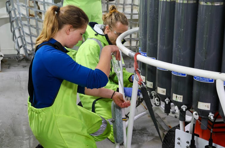 two women examining cylinders