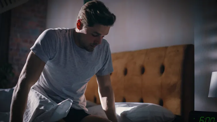 Man sits on end of bed