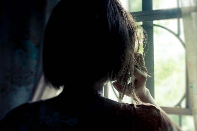 The back of a woman's head seen in silhouette.